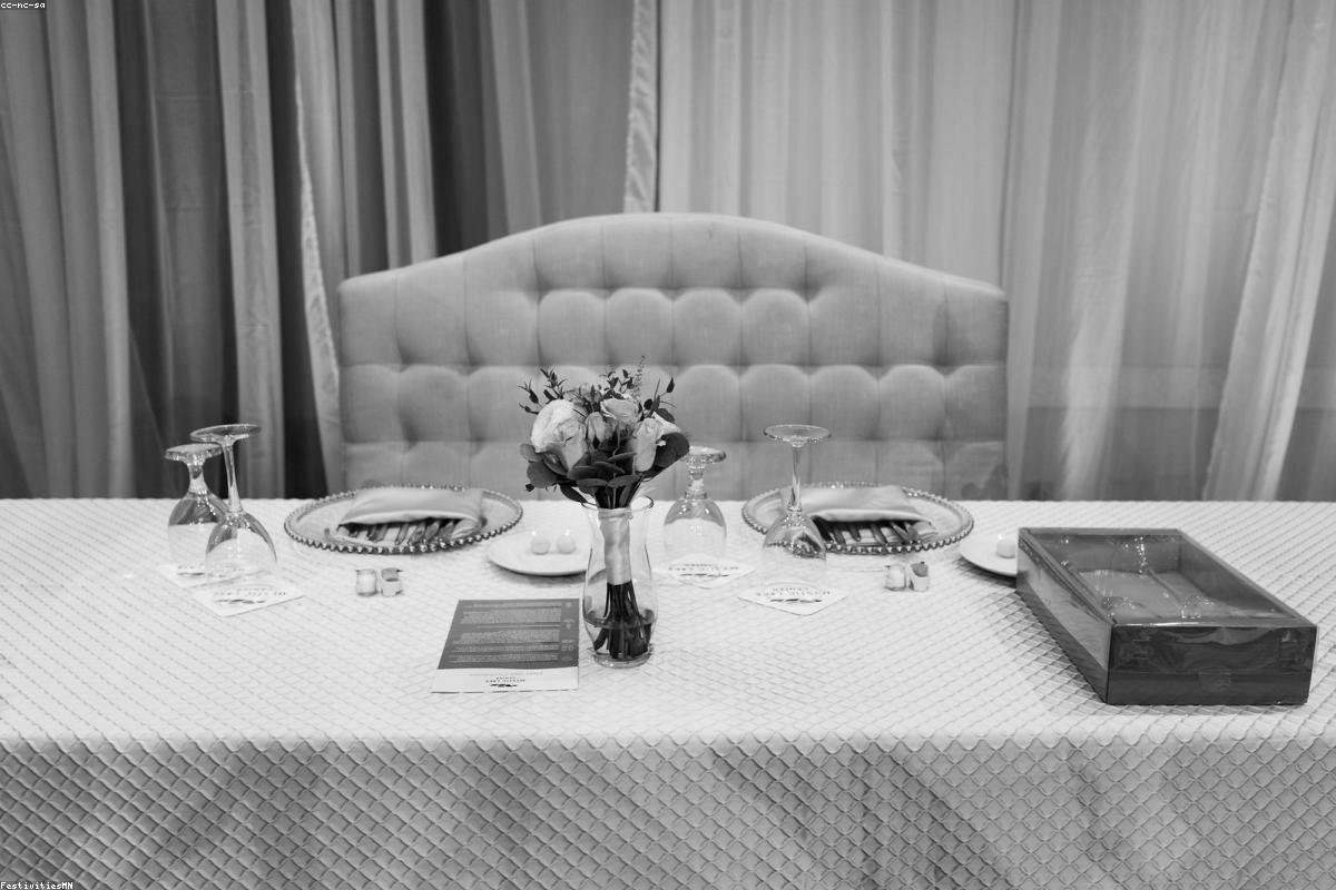 Stół weselny z kieliszkami i bukietem kwiatów